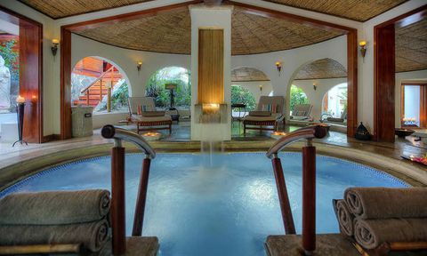 Mini-waterfall feature, well-designed lounge area, and towels in a soaking area at Tabacón.