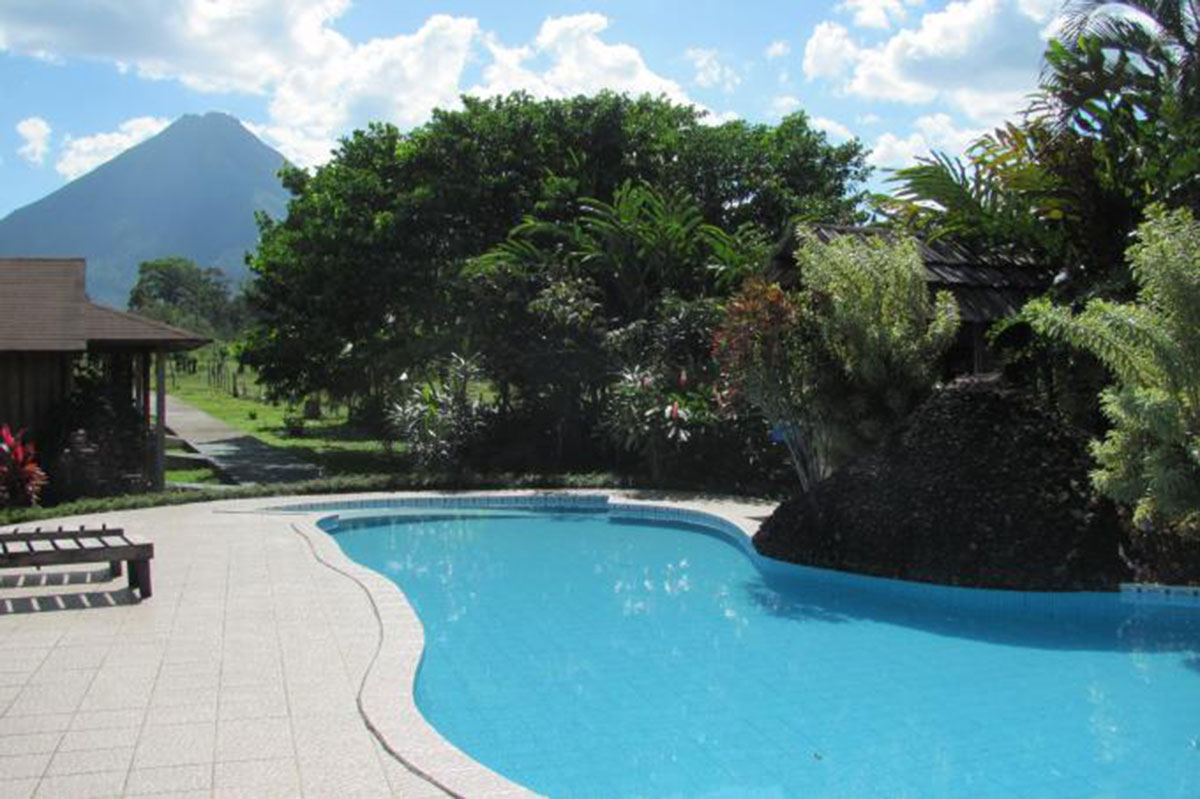A pool and path enjoy a magnificent volcano view.