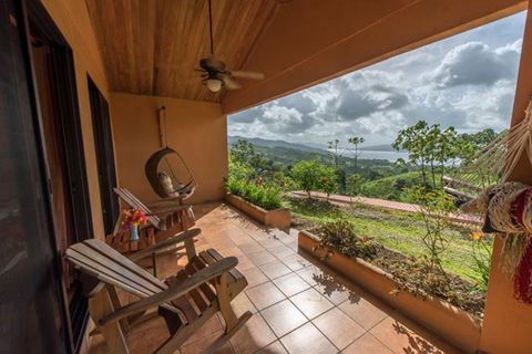 Two rocking chairs, a suspended chair, and a hammock positioned for enjoying the view at Nepenthe
Bed and Breakfast.
