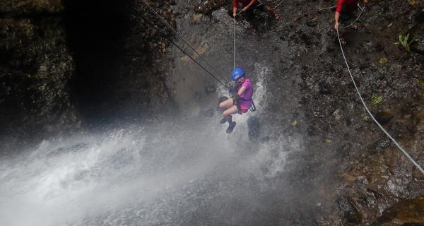 Arenal Water Activities Image: A woman smiles whilst getting splashed as she waterfall rappels.